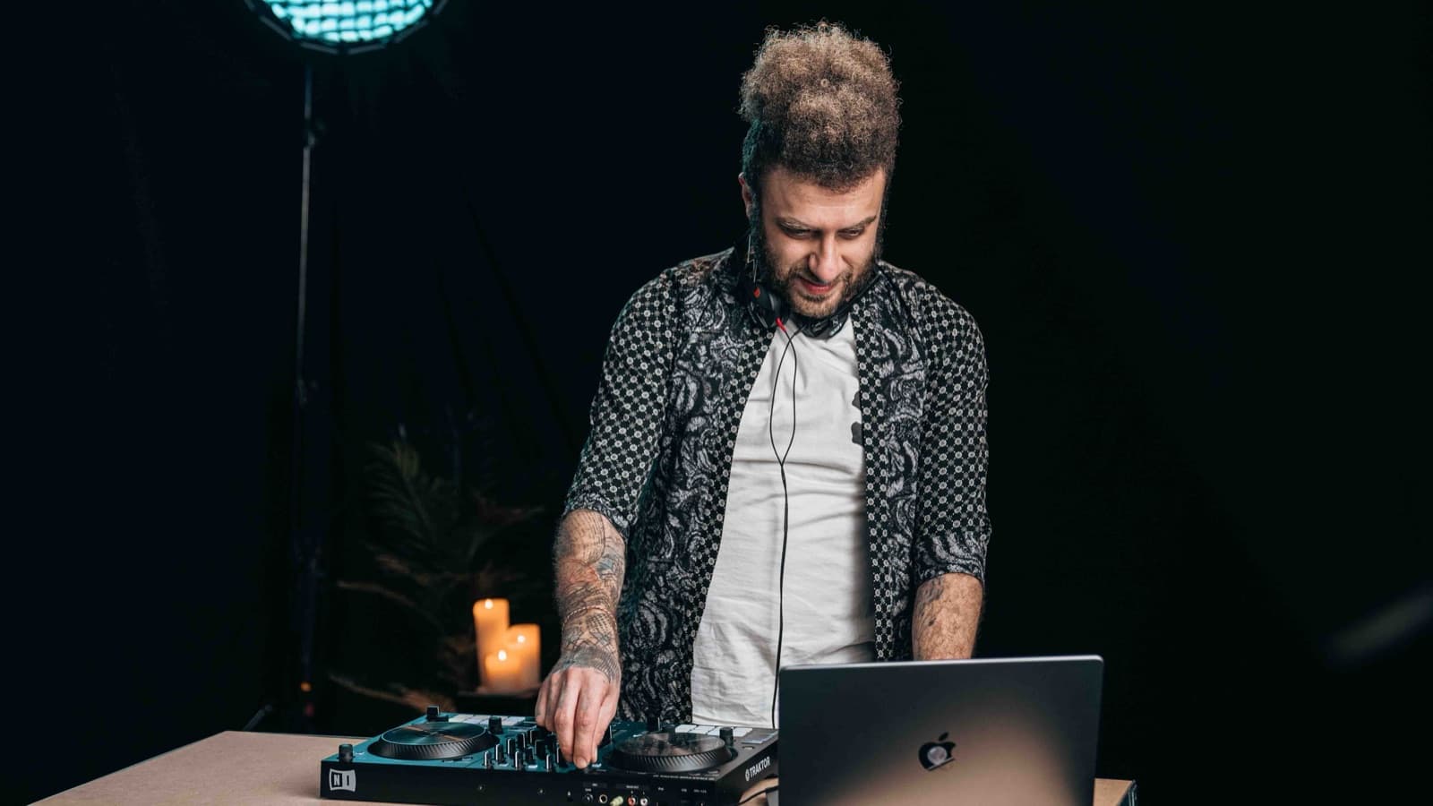 DJ Navid achter de controller, met een discobal